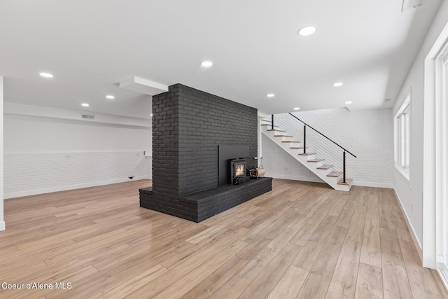 1113 N Lambert Ln, Coeur Dalene, ID 83814 - unfurnished living room featuring brick wall, stairway, a brick fireplace, light wood-style floors, and baseboards