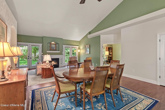 8511 N Summerfield Loop, Hayden, ID 83835 - dining space with french doors, a warm lit fireplace, wood finished floors, high vaulted ceiling, and baseboards