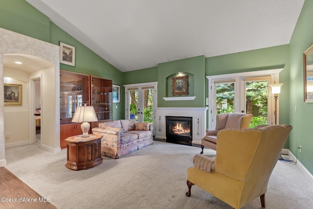 8511 N Summerfield Loop, Hayden, ID 83835 - living area with french doors, a fireplace with flush hearth, baseboards, carpet floors, and high vaulted ceiling