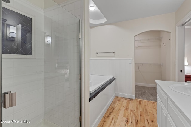 8511 N Summerfield Loop, Hayden, ID 83835 - bathroom featuring wood finished floors, a shower stall, vanity, a garden tub, and wainscoting