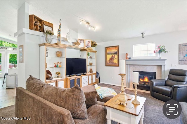 5820 E Steamboat Bnd, Post Falls, ID 83854 - living room featuring plenty of natural light, a tile fireplace, vaulted ceiling, carpet flooring, and baseboards