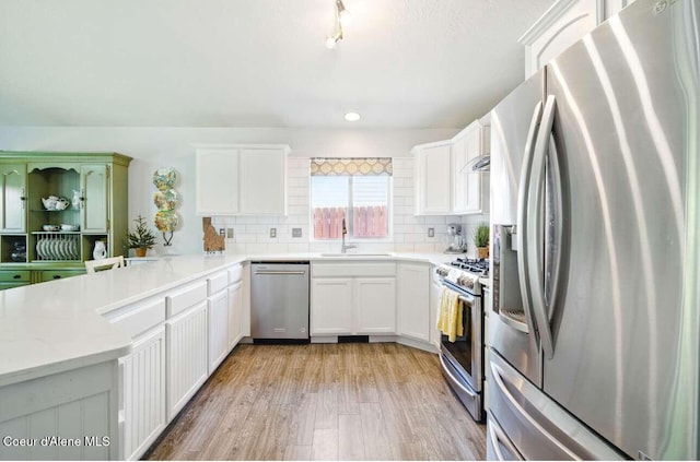 5820 E Steamboat Bnd, Post Falls, ID 83854 - kitchen with stainless steel appliances, a sink, tasteful backsplash, light wood finished floors, and recessed lighting