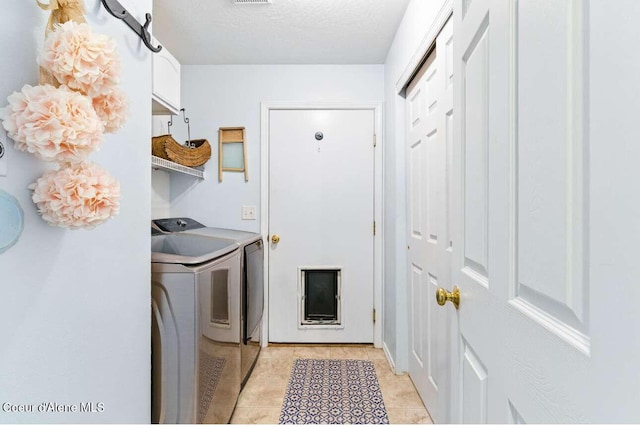 5820 E Steamboat Bnd, Post Falls, ID 83854 - laundry room featuring separate washer and dryer, light tile patterned flooring, and a textured ceiling