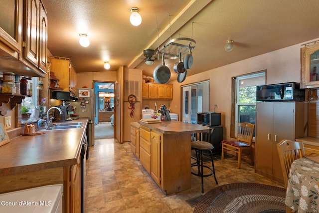 490 Samuels Rd, Sandpoint, ID 83864 - kitchen featuring a sink, a kitchen breakfast bar, stainless steel microwave, ceiling fan, and dark countertops