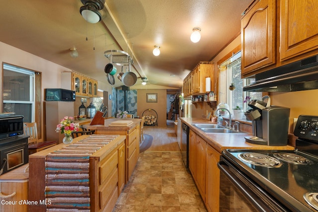 490 Samuels Rd, Sandpoint, ID 83864 - kitchen featuring black appliances, under cabinet range hood, a sink, brown cabinetry, and a kitchen island
