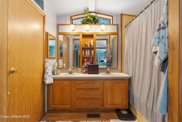 490 Samuels Rd, Sandpoint, ID 83864 - full bathroom featuring wood finished floors, double vanity, lofted ceiling, and a shower with shower curtain