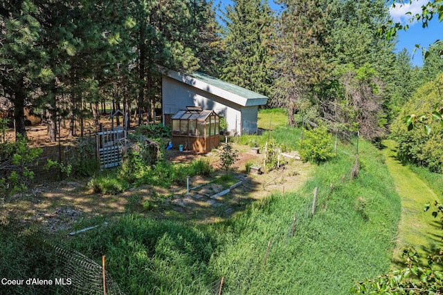 490 Samuels Rd, Sandpoint, ID 83864 - view of yard featuring a greenhouse and an outdoor structure