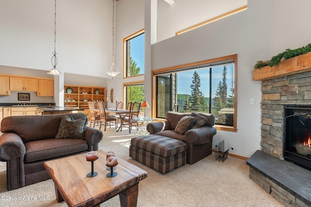 227 Crystal Springs Rd # 3, Sandpoint, ID 83864 - living area featuring a towering ceiling, light carpet, a stone fireplace, and baseboards
