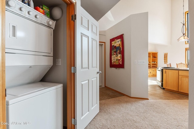 227 Crystal Springs Rd # 3, Sandpoint, ID 83864 - washroom featuring estacked washer and dryer, light carpet, baseboards, and light tile patterned floors