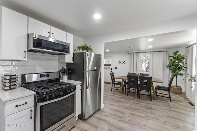 901 N 16th St, Coeur Dalene, ID 83814 - kitchen with appliances with stainless steel finishes, backsplash, light countertops, light wood finished floors, and recessed lighting