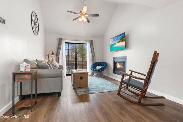 228 Snowgoose Ln Unit 8, Sandpoint, ID 83864 - living area with wood finished floors, a glass covered fireplace, baseboards, a ceiling fan, and high vaulted ceiling