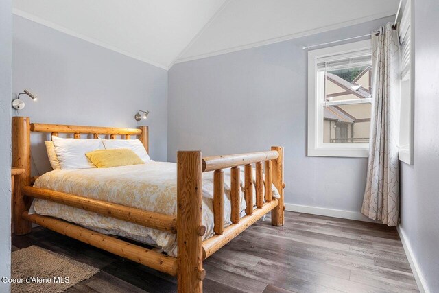 228 Snowgoose Ln Unit 8, Sandpoint, ID 83864 - bedroom featuring lofted ceiling, ornamental molding, wood finished floors, and baseboards