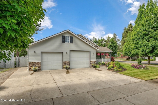 5835 E Steamboat Bnd, Post Falls, ID 83854 - view of front of home featuring a porch, stone siding, a garage, and a gate