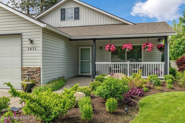 5835 E Steamboat Bnd, Post Falls, ID 83854 - view of front facade with a shingled roof, a porch, a garage, and board and batten siding
