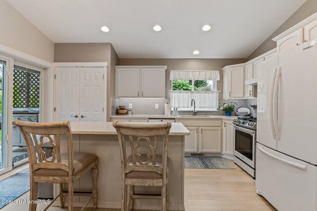 5835 E Steamboat Bnd, Post Falls, ID 83854 - kitchen featuring freestanding refrigerator, stainless steel range, a sink, light countertops, and decorative backsplash