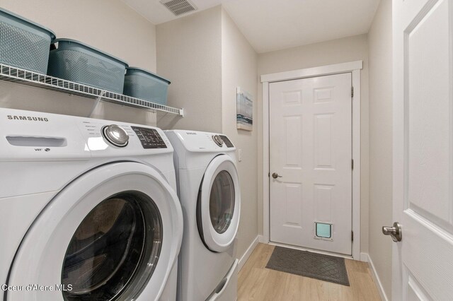 5835 E Steamboat Bnd, Post Falls, ID 83854 - laundry room featuring light wood-type flooring, washer and clothes dryer, and baseboards