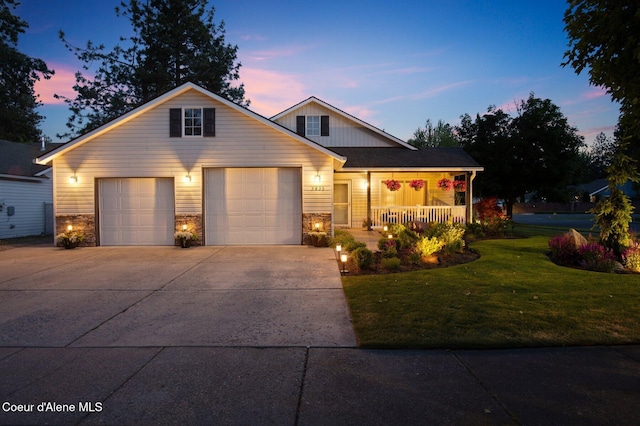 5835 E Steamboat Bnd, Post Falls, ID 83854 - view of front of property featuring covered porch, a yard, stone siding, concrete driveway, and a garage
