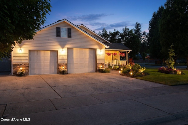 5835 E Steamboat Bnd, Post Falls, ID 83854 - view of front of house featuring a porch, driveway, a garage, stone siding, and a front yard