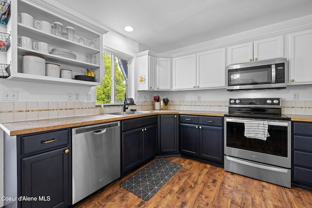 688 N Sparklewood Ct, Post Falls, ID 83854 - kitchen with appliances with stainless steel finishes, a sink, white cabinetry, dark wood finished floors, and blue cabinetry