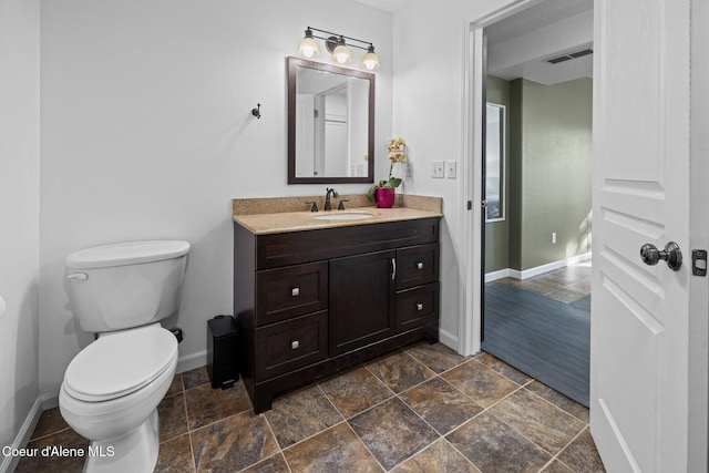 688 N Sparklewood Ct, Post Falls, ID 83854 - bathroom featuring baseboards, vanity, toilet, and stone finish flooring
