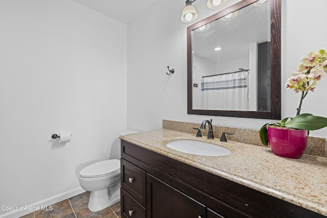 688 N Sparklewood Ct, Post Falls, ID 83854 - bathroom with vanity, baseboards, toilet, and stone finish floors