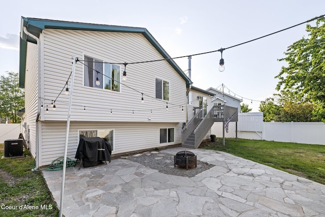 688 N Sparklewood Ct, Post Falls, ID 83854 - rear view of property featuring a patio area, cooling unit, a fire pit, and stairway