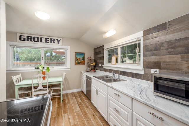 1409 E Birch Ave, Coeur Dalene, ID 83814 - kitchen with a sink, stainless steel dishwasher, vaulted ceiling, light wood-type flooring, and white cabinets