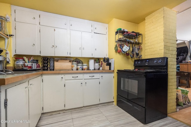 511 E Spring St, Oldtown, ID 83822 - kitchen featuring black range with electric stovetop, white cabinets, and a sink