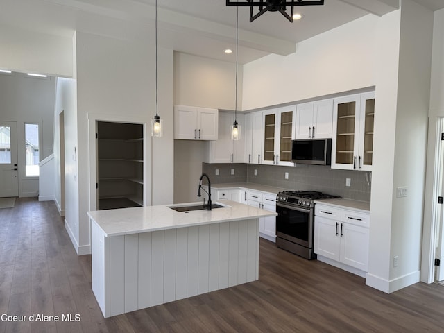 9151 N Raintree Ln, Hayden, ID 83835 - kitchen with stainless steel appliances, a sink, a high ceiling, a kitchen island with sink, and tasteful backsplash