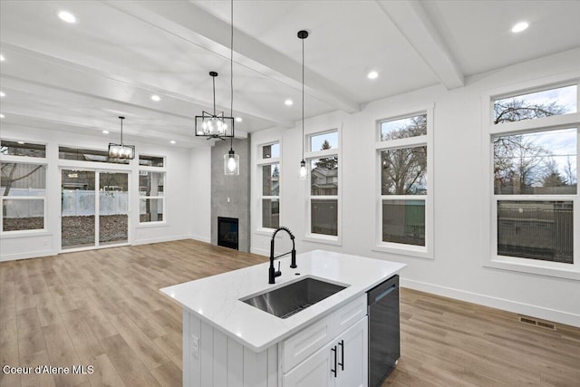 9151 N Raintree Ln, Hayden, ID 83835 - kitchen with a sink, dishwashing machine, light wood-style flooring, baseboards, and beamed ceiling