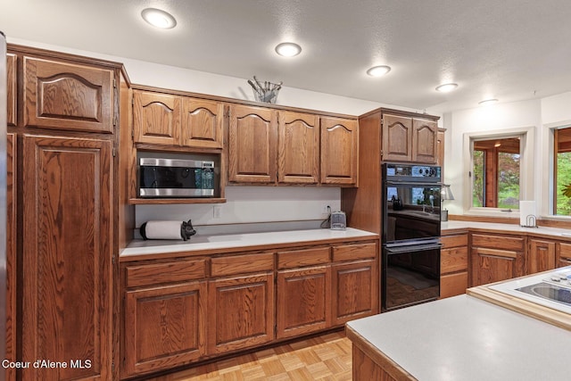 15248 N Atlas Rd, Rathdrum, ID 83858 - kitchen with stainless steel microwave, light countertops, and brown cabinetry