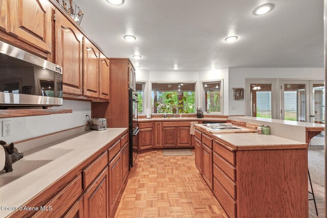15248 N Atlas Rd, Rathdrum, ID 83858 - kitchen with stainless steel microwave, a breakfast bar, light countertops, a center island, and recessed lighting