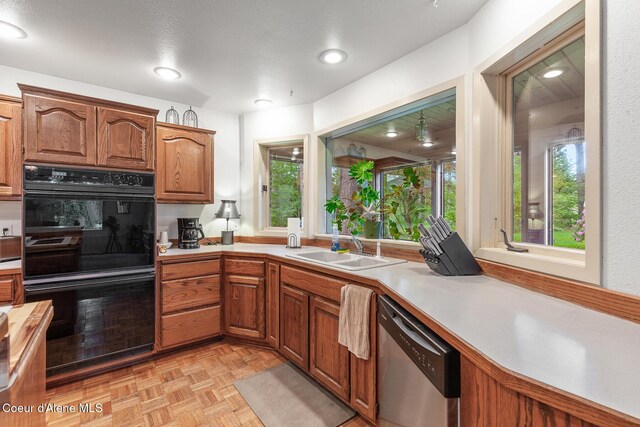 15248 N Atlas Rd, Rathdrum, ID 83858 - kitchen with dishwasher, light countertops, a sink, and brown cabinetry