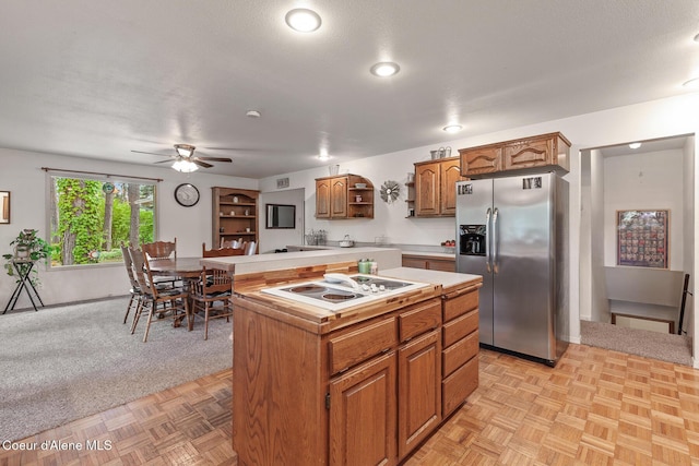 15248 N Atlas Rd, Rathdrum, ID 83858 - kitchen with stainless steel fridge with ice dispenser, white electric cooktop, open shelves, light countertops, and brown cabinetry