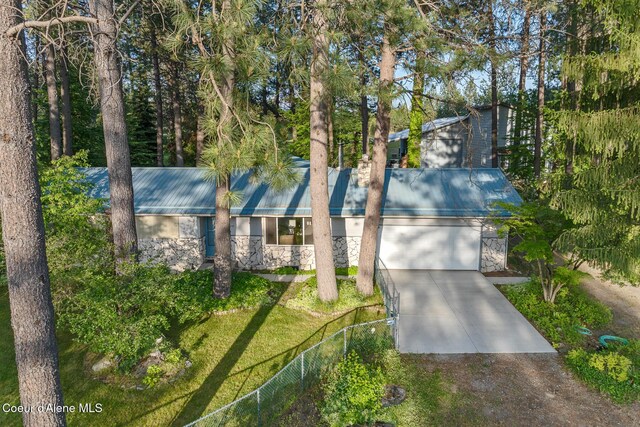 15248 N Atlas Rd, Rathdrum, ID 83858 - mid-century inspired home featuring driveway, stone siding, an attached garage, metal roof, and a chimney