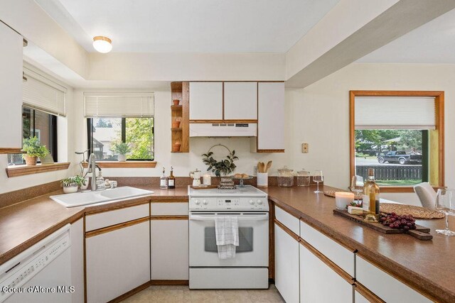1130 E Timber Ln # 2, Coeur Dalene, ID 83815 - kitchen with white appliances, under cabinet range hood, a sink, white cabinetry, and dark countertops