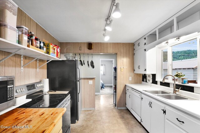 316 W Brown Ave, Kellogg, ID 83837 - kitchen with stainless steel appliances, a sink, wooden walls, open shelves, and white cabinetry