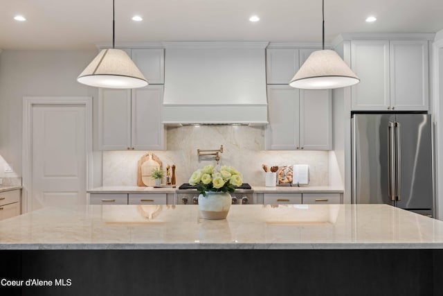 287 Mesa Dr, Athol, ID 83801 - kitchen featuring freestanding refrigerator, premium range hood, recessed lighting, tasteful backsplash, and light stone countertops