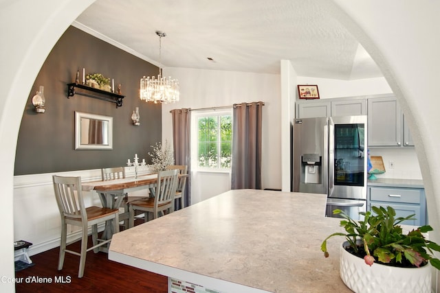 500 N Elm Rd, Post Falls, ID 83854 - kitchen with stainless steel fridge with ice dispenser, arched walkways, dark wood finished floors, hanging light fixtures, and a chandelier
