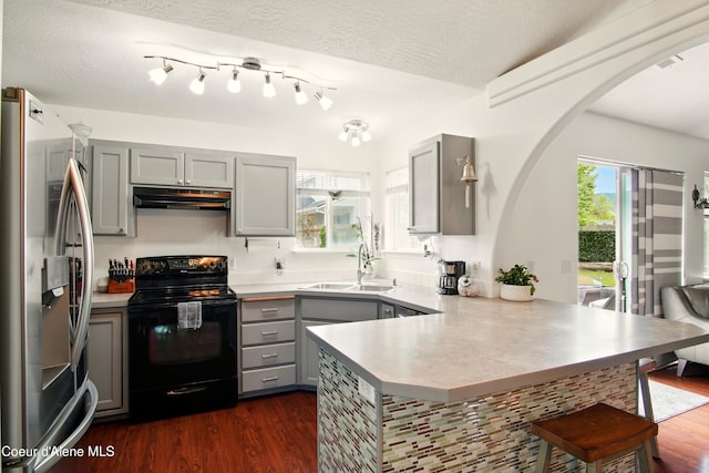 500 N Elm Rd, Post Falls, ID 83854 - kitchen with black electric range, freestanding refrigerator, gray cabinetry, a sink, and under cabinet range hood