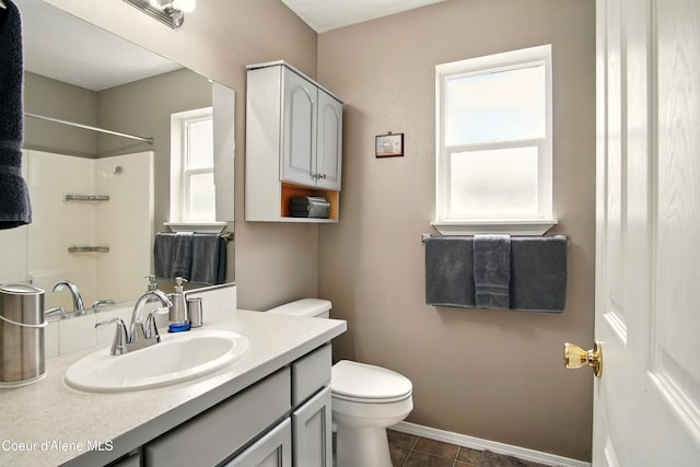 500 N Elm Rd, Post Falls, ID 83854 - bathroom featuring toilet, vanity, baseboards, and a shower