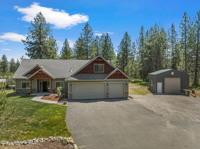 23378 N Prominence Rd, Rathdrum, ID 83858 - craftsman house featuring stone siding, a front yard, driveway, and a garage