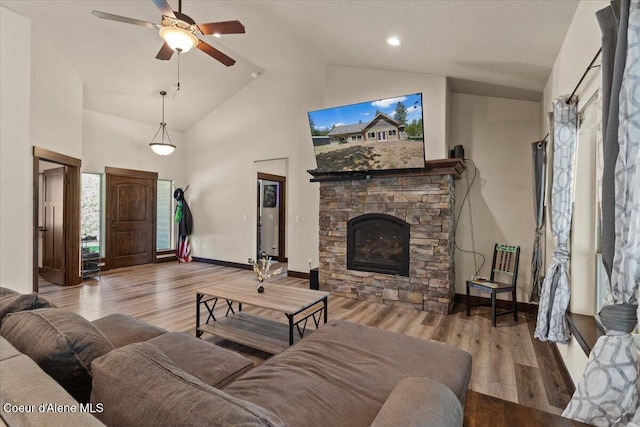 23378 N Prominence Rd, Rathdrum, ID 83858 - living room featuring ceiling fan, a stone fireplace, high vaulted ceiling, and wood finished floors