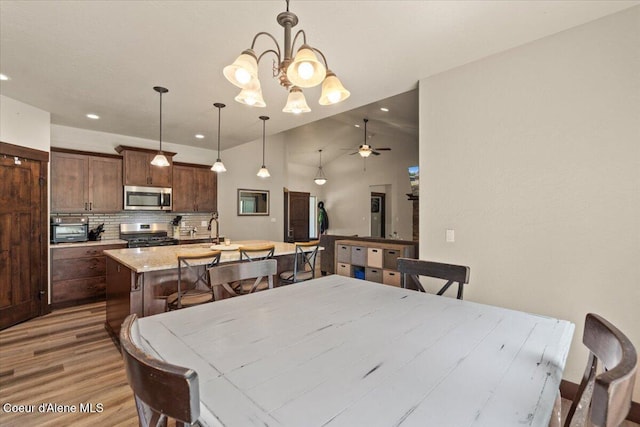 23378 N Prominence Rd, Rathdrum, ID 83858 - dining room featuring wood finished floors, a chandelier, vaulted ceiling, and recessed lighting