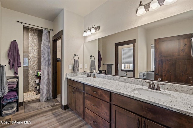 23378 N Prominence Rd, Rathdrum, ID 83858 - bathroom featuring wood finished floors, double vanity, and a tile shower