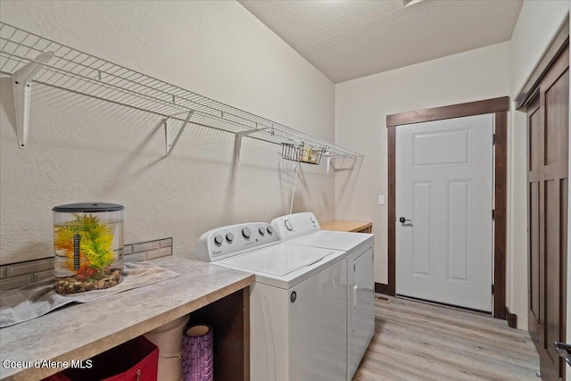 23378 N Prominence Rd, Rathdrum, ID 83858 - laundry room with washer and clothes dryer, light wood finished floors, and a textured wall