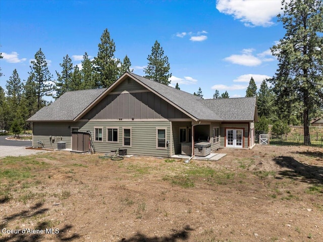 23378 N Prominence Rd, Rathdrum, ID 83858 - back of house with board and batten siding, french doors, roof with shingles, a patio area, and a hot tub