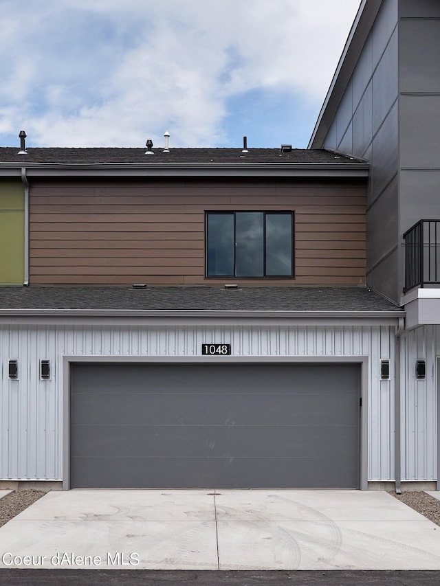 1048 E 4th Ave, Post Falls, ID 83854 - view of front of home featuring a garage, board and batten siding, driveway, and roof with shingles