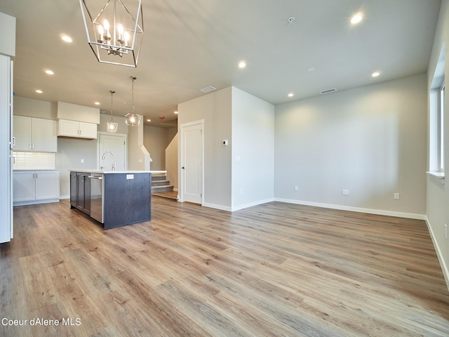 1048 E 4th Ave, Post Falls, ID 83854 - kitchen featuring recessed lighting, a kitchen island with sink, white cabinetry, light wood-type flooring, and decorative light fixtures