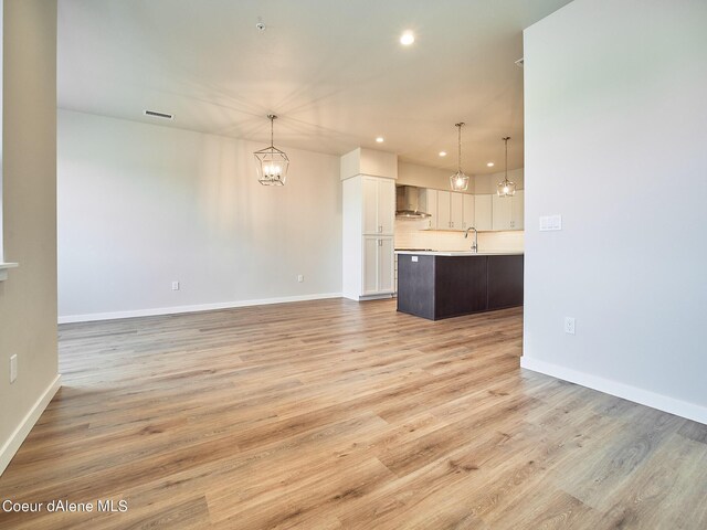 1048 E 4th Ave, Post Falls, ID 83854 - unfurnished living room featuring a chandelier, recessed lighting, light wood finished floors, and baseboards